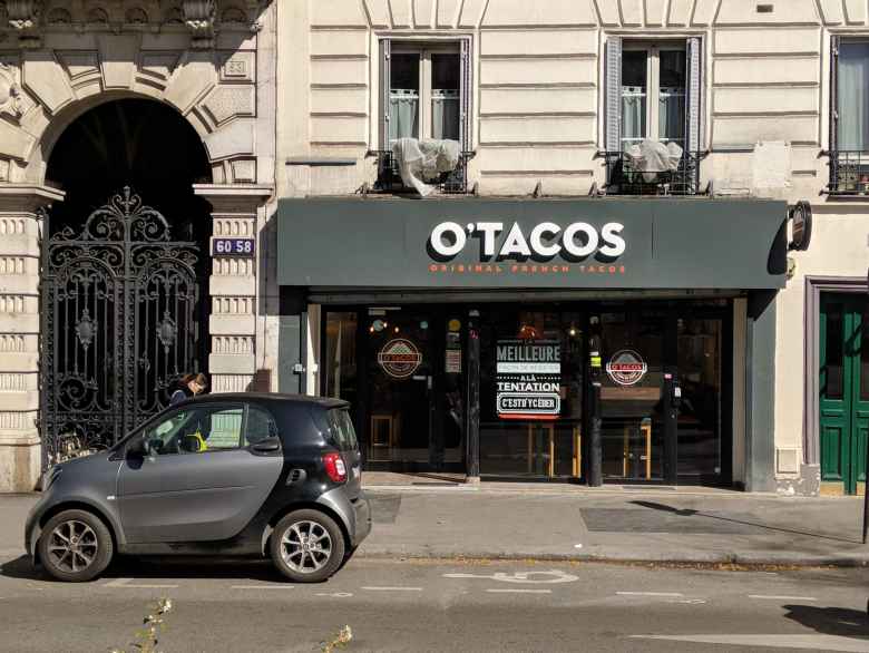 A Smart car in front of O'Tacos in the red light district of Paris.