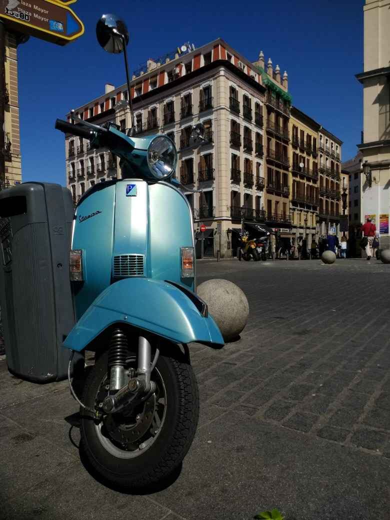 The front of a teal Vespa in Madrid.