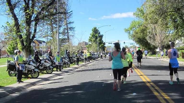 Police officers and motorcycles lining the 2015 Colfax Half Marathon course, runners