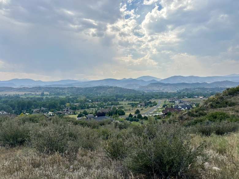 The view of the Rocky Mountains from Devil's Backbone. You can see Long's Peak (14,251')—the most northern 14er in Colorado—to the right of Mt. Meeker (13,811') in the left third of the photo. They are the twin peaks that are kind of faint behind the storm clouds.