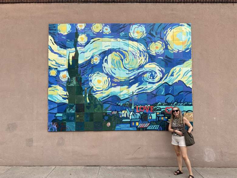 Andrea in front of a starry night-themed mural in downtown Loveland.