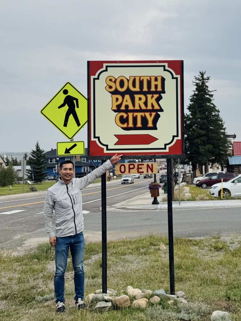 Felix next to a South Park City sign in Fairplay, Colorado.