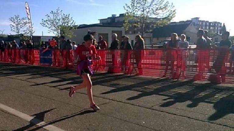 Maureen running in the final stretch of the Colorado Marathon 10k, red shirt, Team Beef