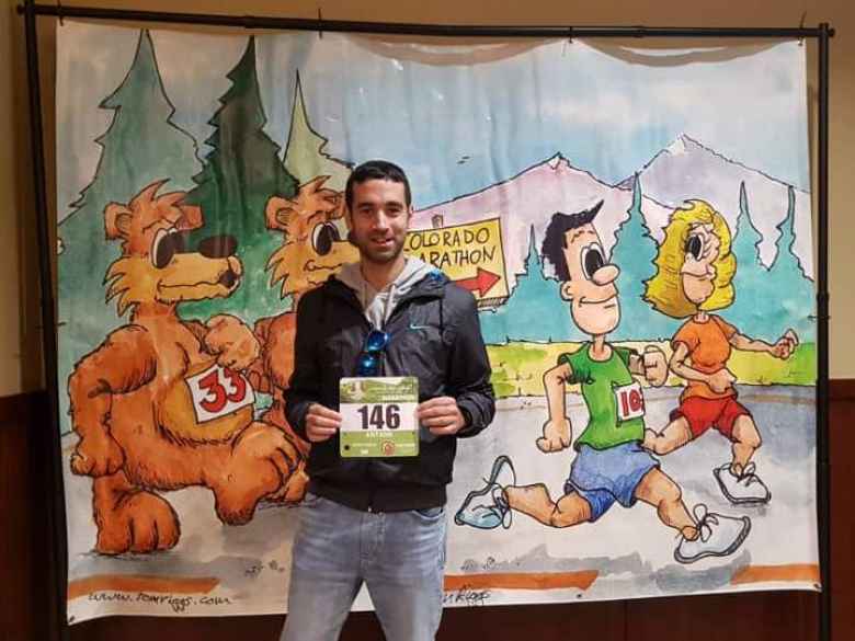 Antxon in front of a large cartoon drawing at the expo for the 2019 Colorado Marathon.