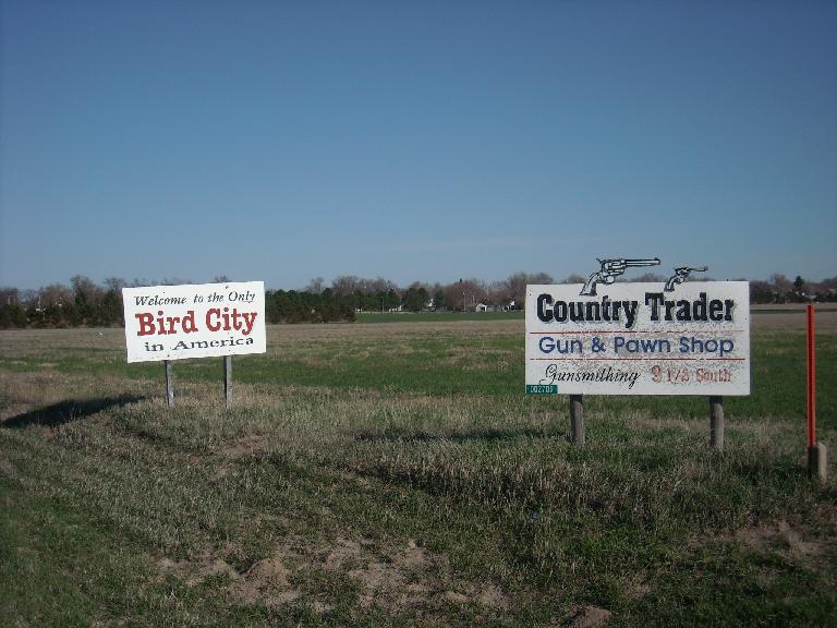 "Welcome to the only Bird City in America."  Also an ad for a gun & pawn shop.