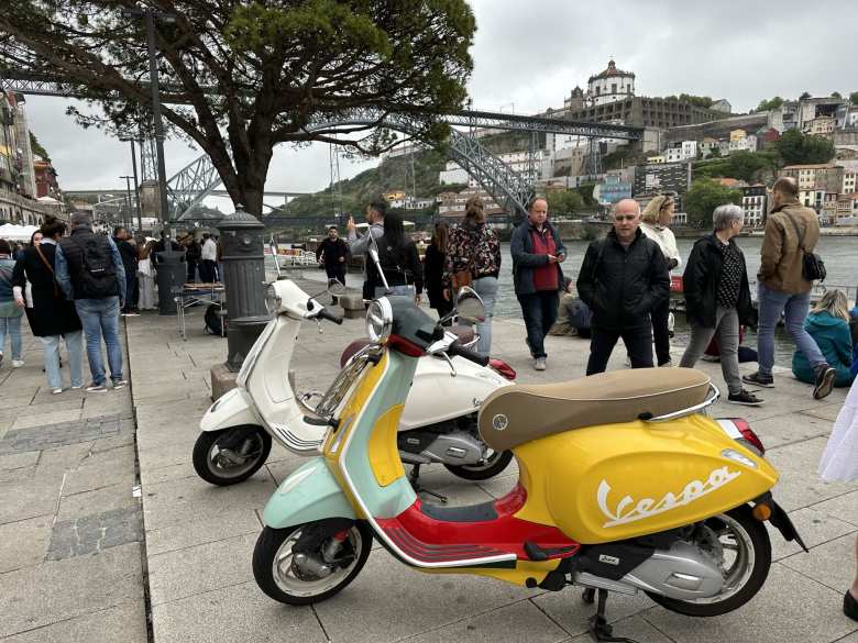 A pair of Vespas in front of the Puente Don Luis I bridge in Porto, Portugal.