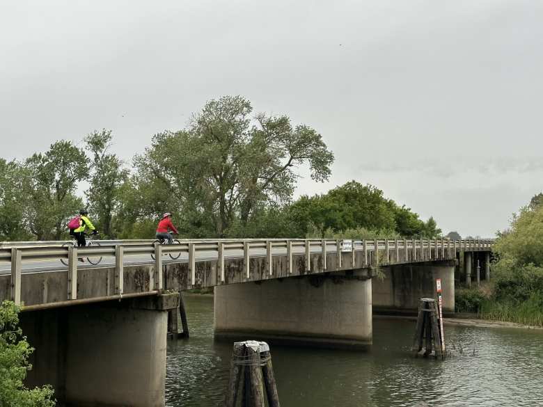 Two cyclists riding flat-bar bicycles riding across a bridge during the Delta Century.
