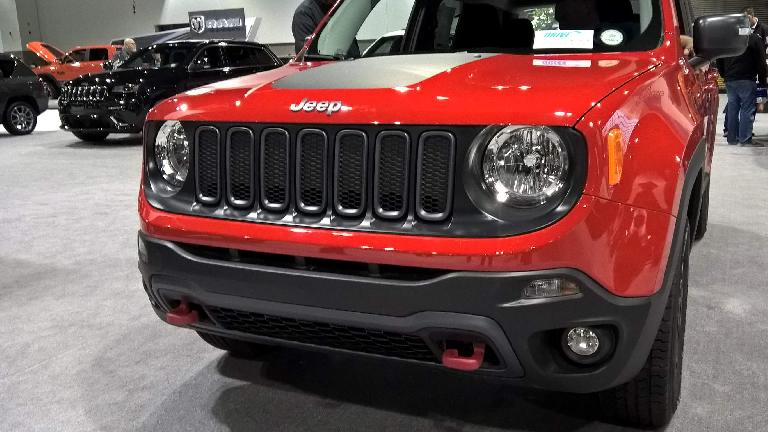 The cheerful face of a red 2016 Jeep Renegade.