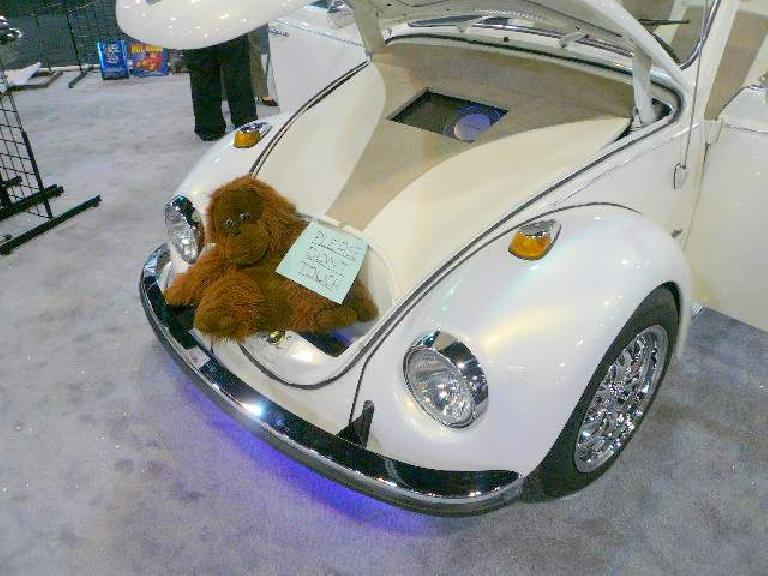 A monkey in the trunk of a pimped-out old VW Beetle.