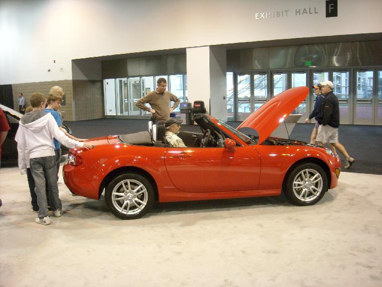 An orange-red Mazda MX-5, Leah's favorite car of the show.