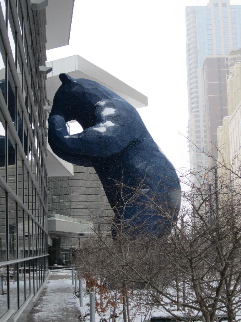 The Blue Bear peaking into the Denver Convention Center to look at cars.