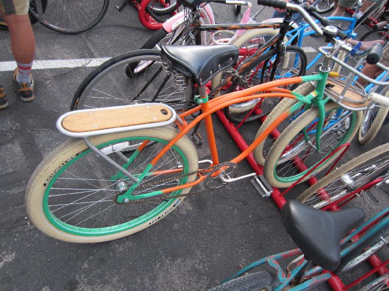 Orange and green cruiser with wooden rear rack.