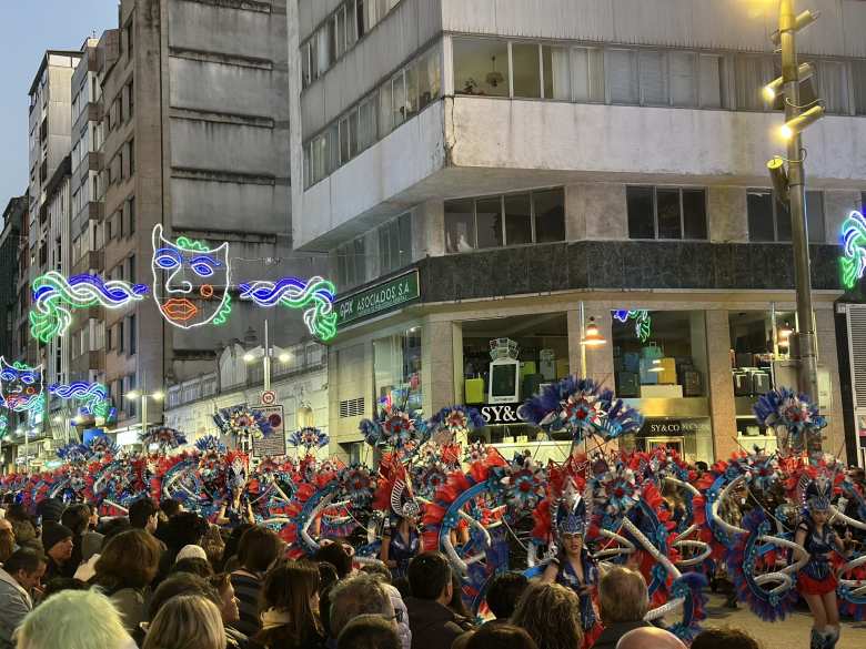 Schoolgirls dressed up in blue, white, and red-feathered costumes.