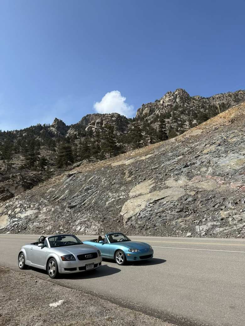 My Audi TT Roadster Quattro and Manuel's Miata in Loveland, with a tall rock formation in the background.