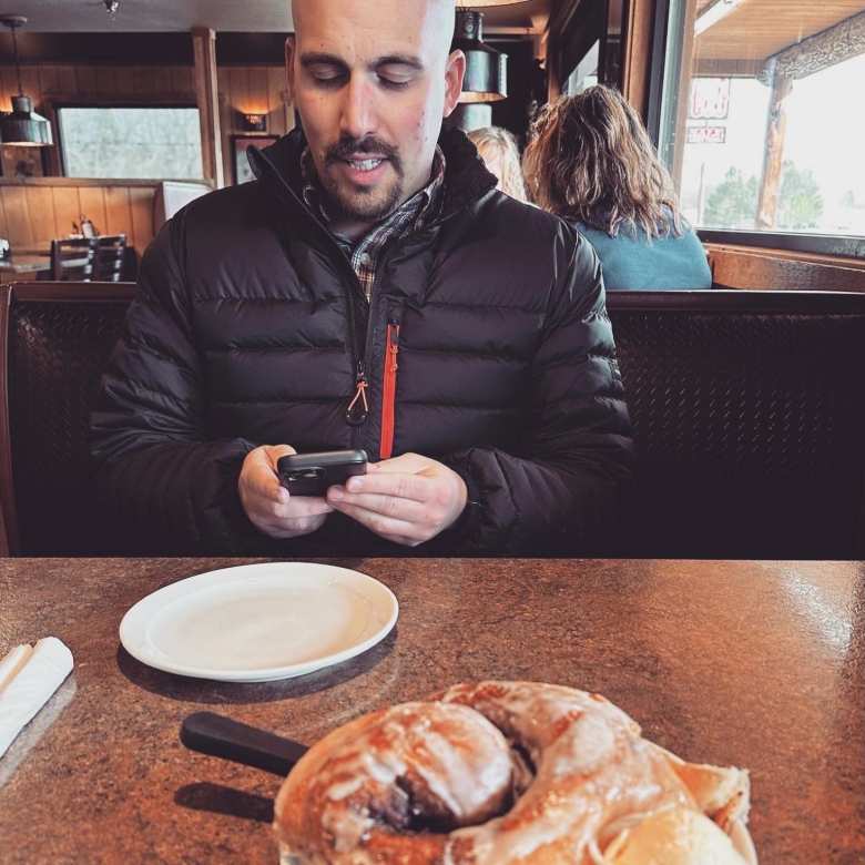 Manuel readying his iPhone inside Vern's Place in Laporte to take a photo. We enjoyed an enormous cinnamon roll that was baked on premise.