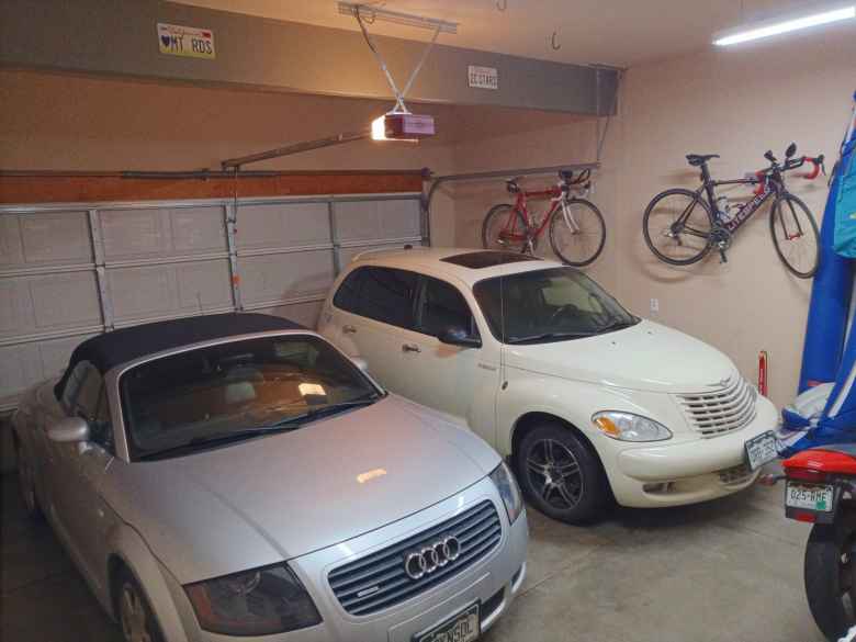 silver Audi TT Roadster Quattro and white 2005 PT Cruiser GT with two bicycles in garage