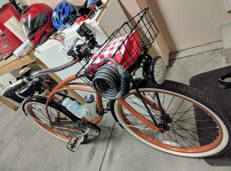 bronze Huffy Cranbrook Cruiser with basket, motorcycle light, and lock in garage