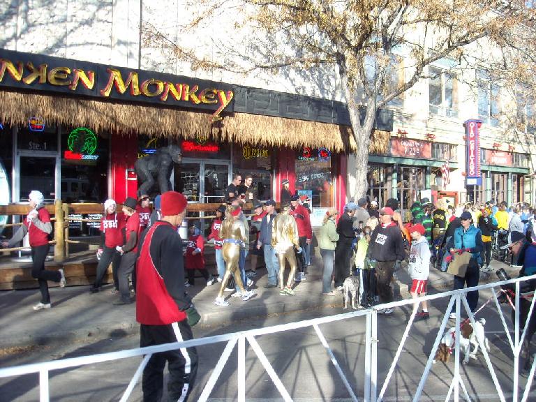 Runners around the start area, including several dressed in shiny bronze costumes.