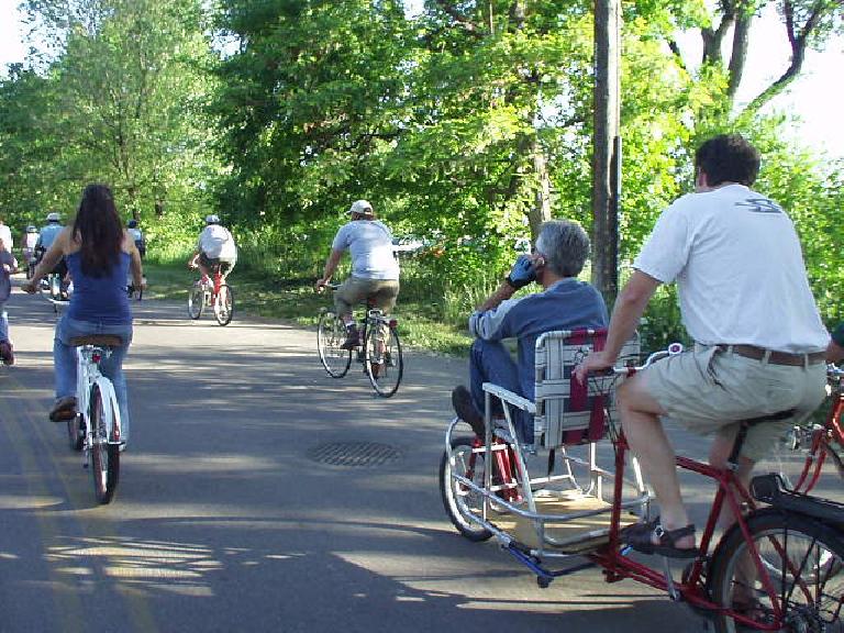 The bike with the lawn chair, with the "captain" talking on a cell phone. The bike with the lawn chair, with the "captain" talking on a cell phone.