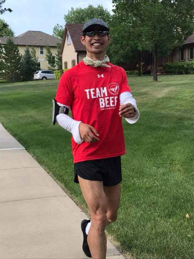 Felix Wong wearing a red Team Beef shirt, white UV sleeves, and a neck bandana for UV protection during the DIY 50 Mile run through the Hearthfire subdivision.