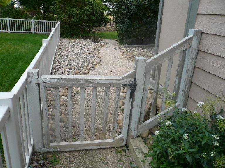 An "before" shot of the front of the side gate and fence.