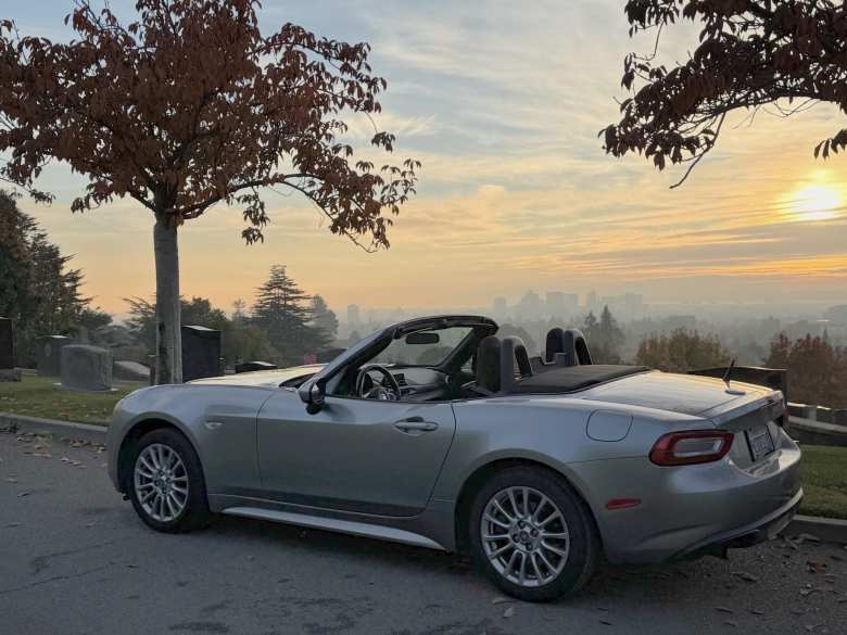 The Aluminum Metallic 2017 FIAT 124 Spider Turo rental at a cemetery in Oakland, California.
