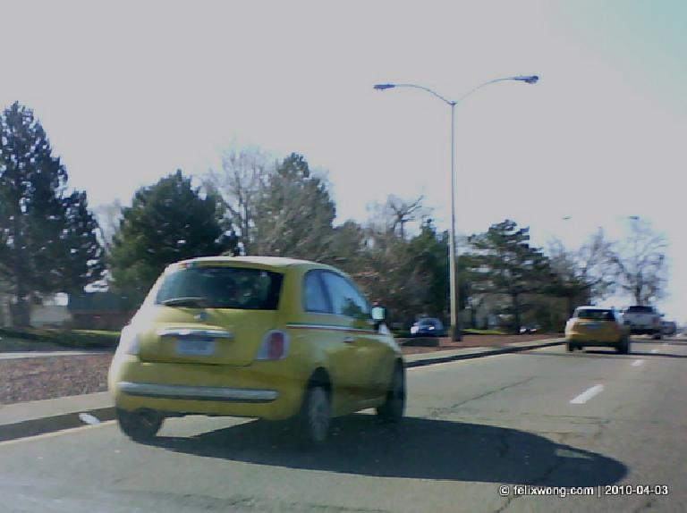 A yellow FIAT 500 prototype on a road in Fort Collins.