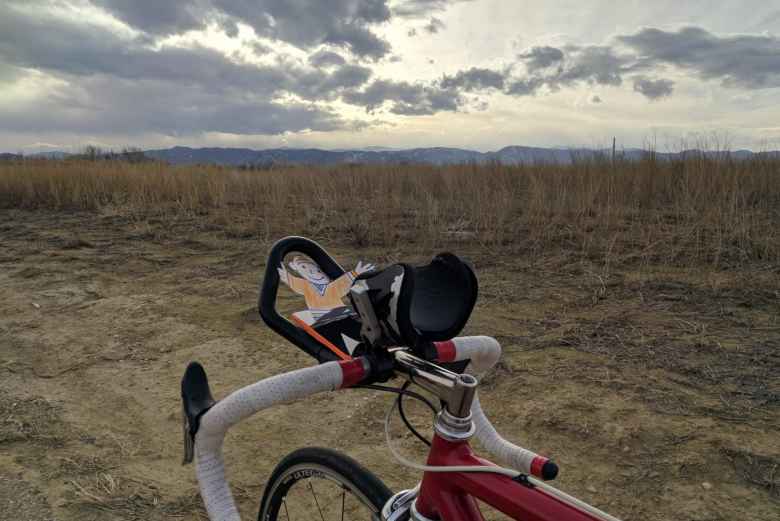 Flat Stanley during a bicycle ride, with the Front Range of Colorado in the background.