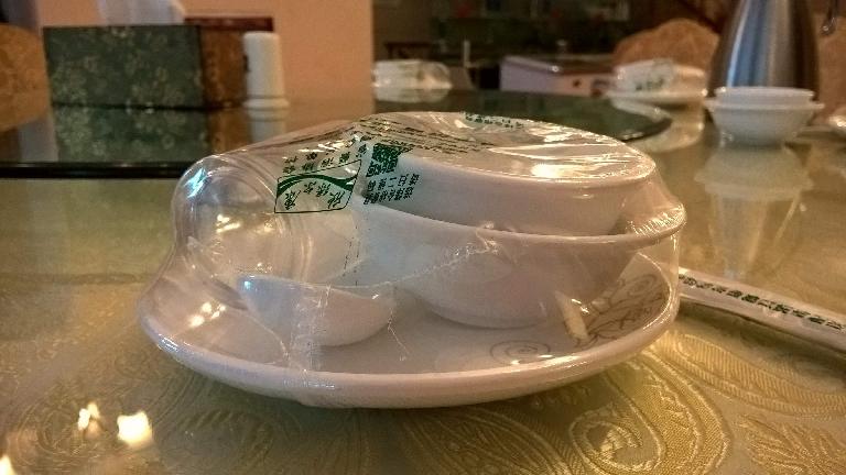 Dishes and utensils wrapped in plastic at a restaurant in Xiamen. I think restaurants in China do this to indicate cleanliness/sterility.
