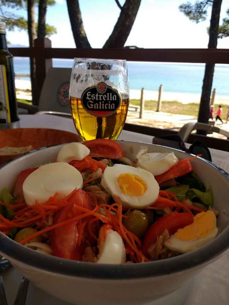 Una ensalada mixta (including eggs, tomatoes, carrots, tuna, and spinach) with a beer in Fisterra, Spain.