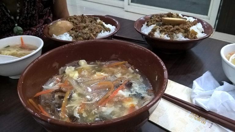 Egg drop soup and bowls of meat and rice at a restaurant in Taoyuan, Taiwan.