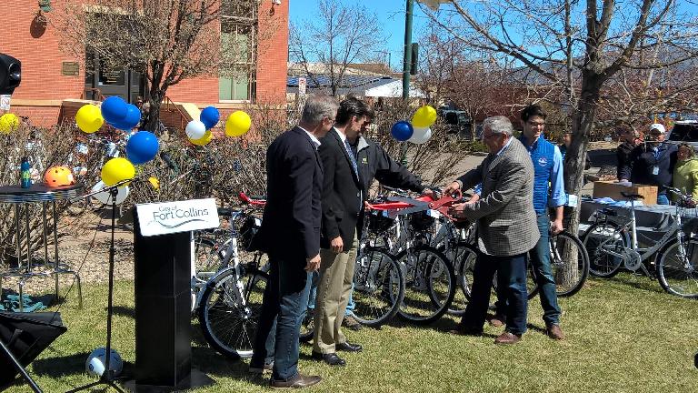 Mayor Wade Troxell cuts a ribbon at the grand unveiling of the Fort Collins Bike Share program.