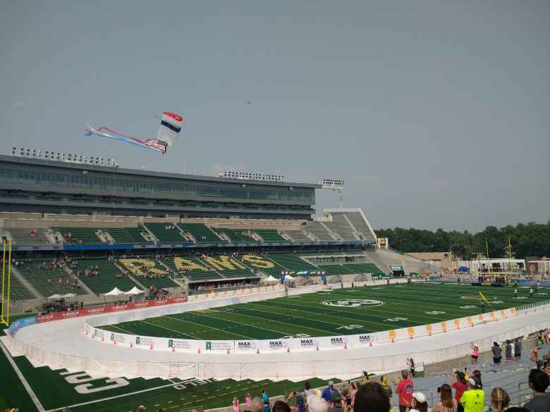 A skydiver bringing in the American flag to the stadium in the post-race activities.