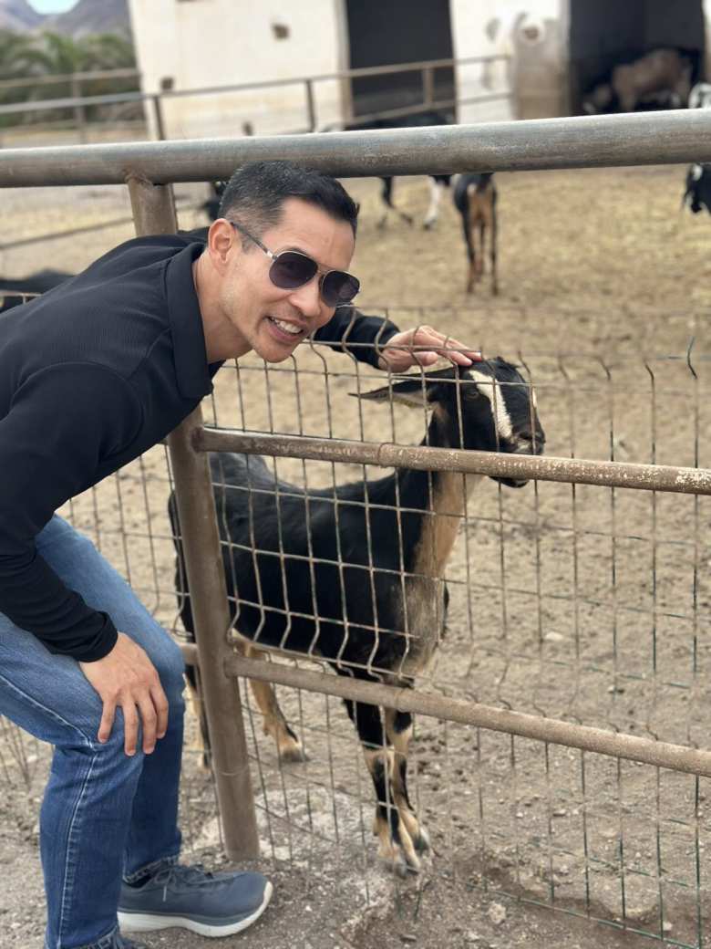 Felix petting a goat.
