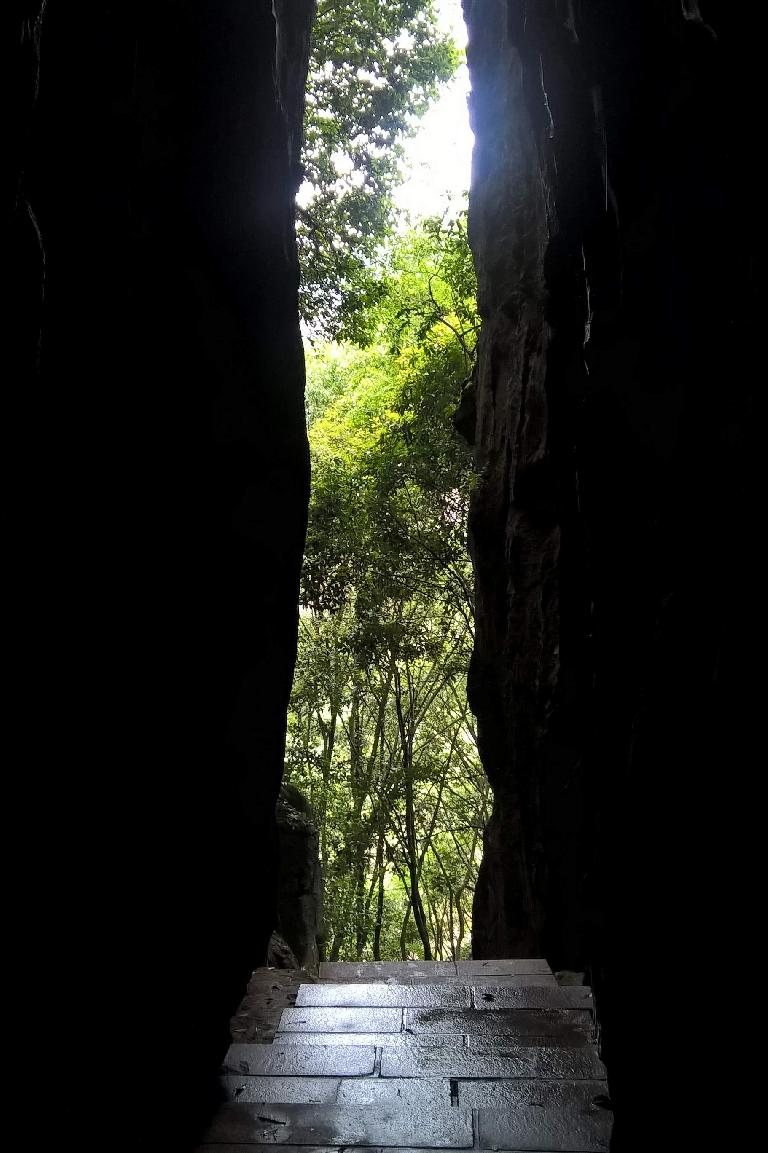 View of trees through an opening between stone walls at the Fujian Linyin Stone Forest.