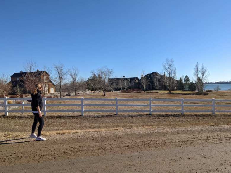 Andrea running by a massive home in north Fort Collins.