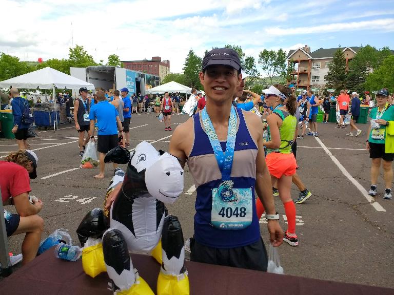 Felix Wong with a chocolate milk cow after the 2017 Grandma's Marathon.