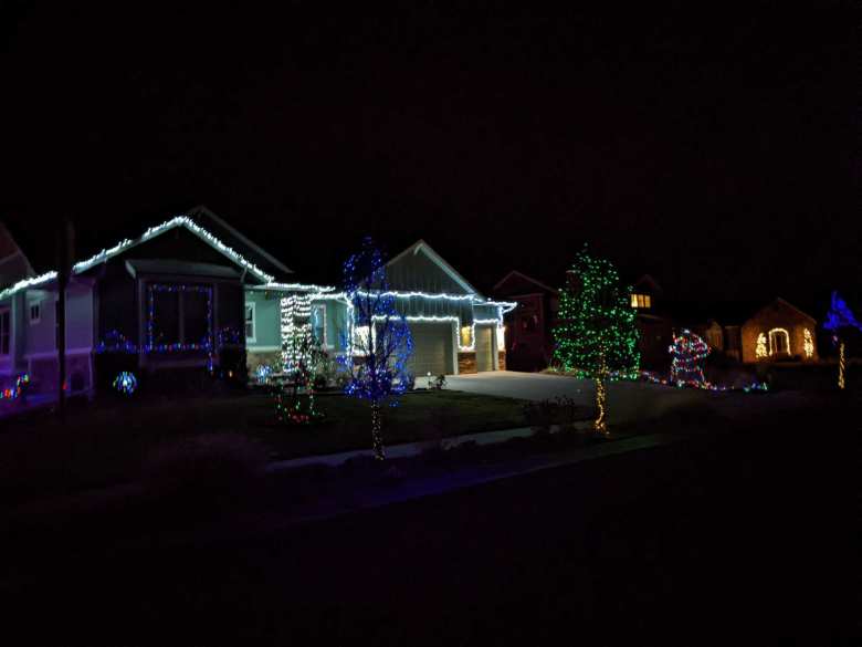 A home and tree by the sidewalk with Christmas lights in the Hearthfire subdivision.