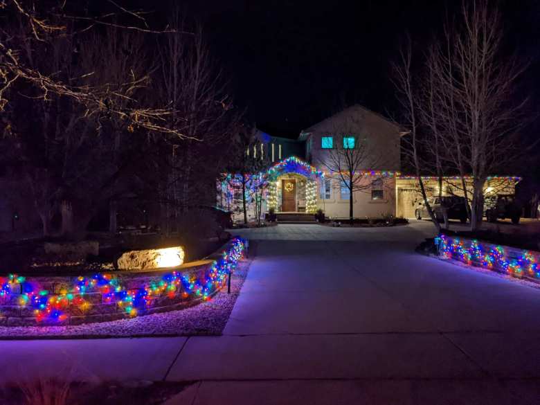 A big house in Hearthfire with Christmas lights lining the driveway.