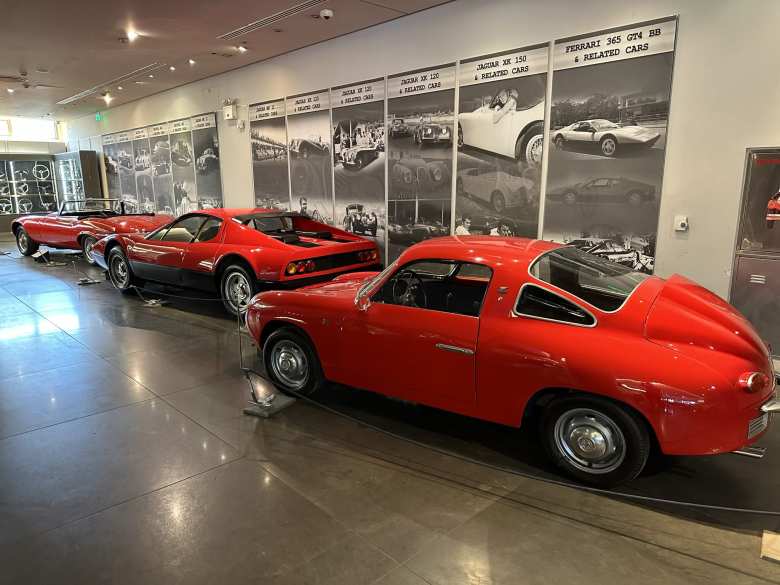 A red Abarth 750 Zagato Record, Ferrari, and Jaguar E-Type convertible.