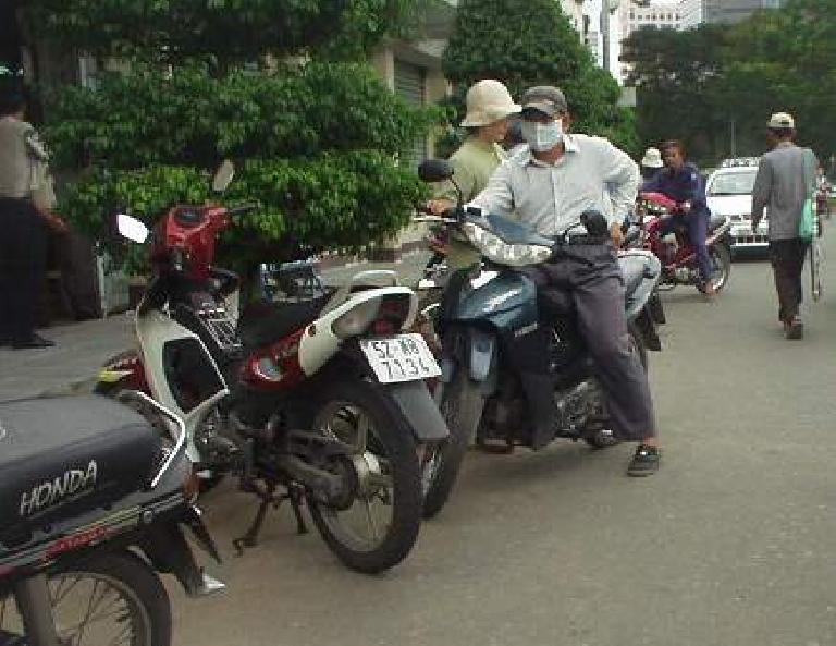 Masked motorbiker.  Usually, you see the women wearing the masks here.