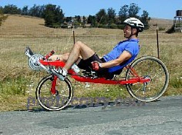 Felix Wong on his red Reynolds Wishbone recumbent in the 2001 Holstein Hundred. Felix Wong, blue jersey, red Reynolds Wishbone recumbent, 2001 Holstein Hundred