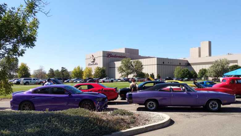 A purple, modern Dodge Charger sedan with a 1970 Dodge Charger coupe. Amazing that the original coupe was longer than the present-day sedan.