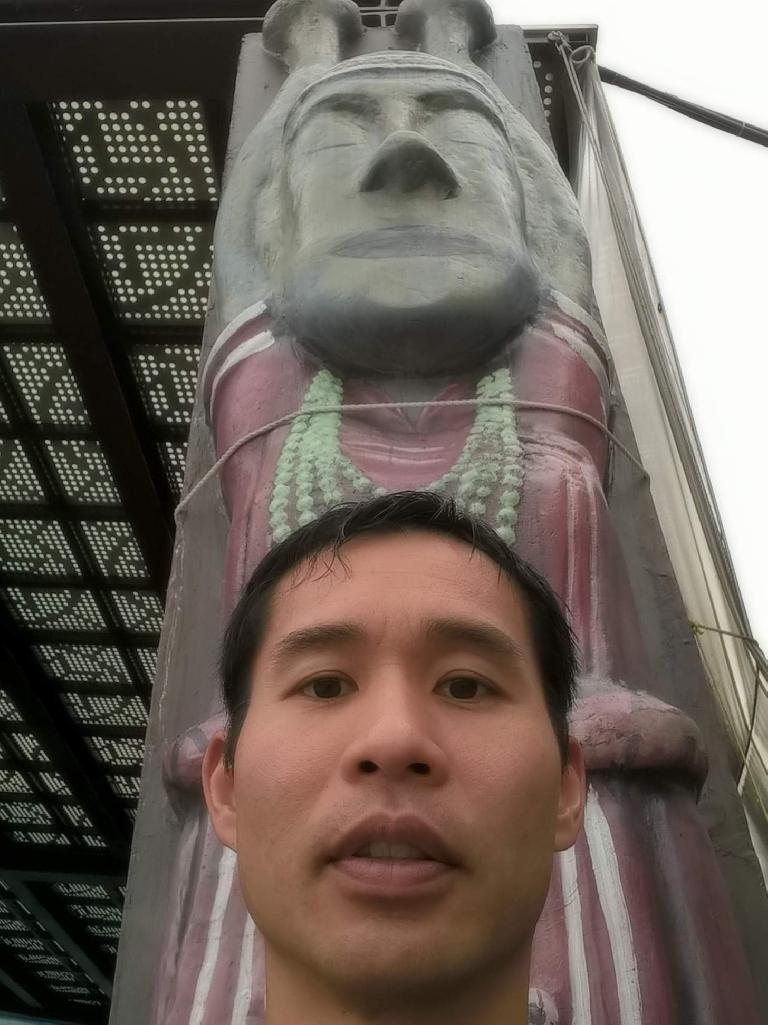 Felix Wong in front of a wood carving at the Tropic of Cancer marker off Highway 11 on the east coast of Taiwan.