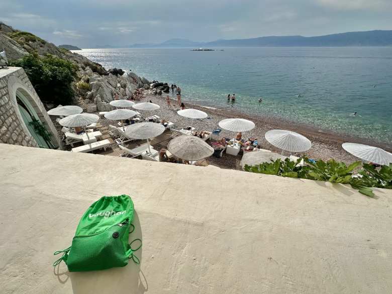 My green bag from VaughanTown on a ledge in front of Kamini beach, where we swam.