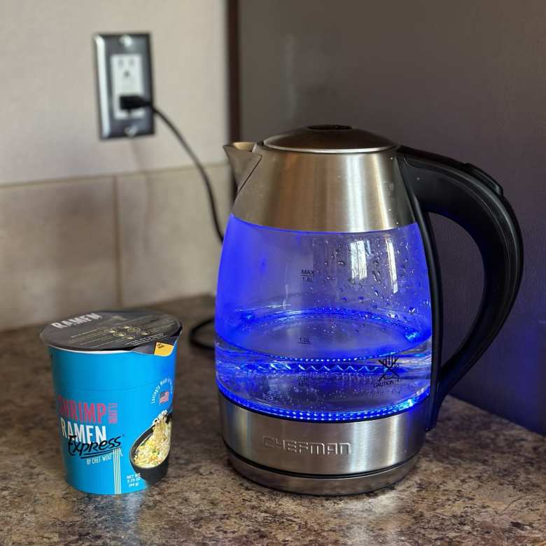 A cup of Shrimp Ramen Express and a Chefman kettle heating up water.