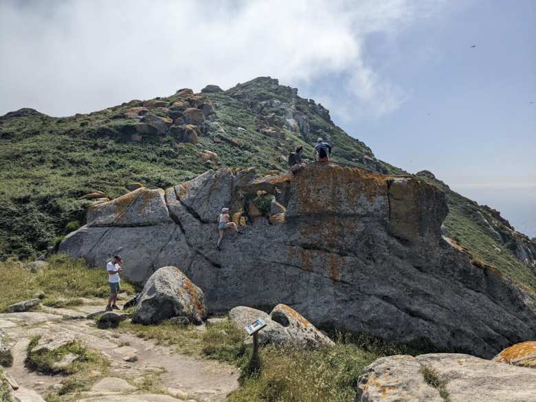 A German woman climbing up the Pedra da Campá (Bell Rock) at Islas Cíes.