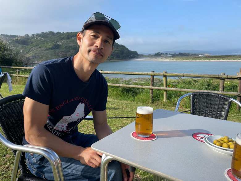 Felix with olives and a caña of Estrella Galicia in the evening, with a lagoon in the background.