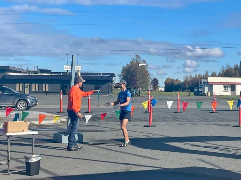 A race volunteer handed me a finisher's medal after completing the Kenai River Marathon.