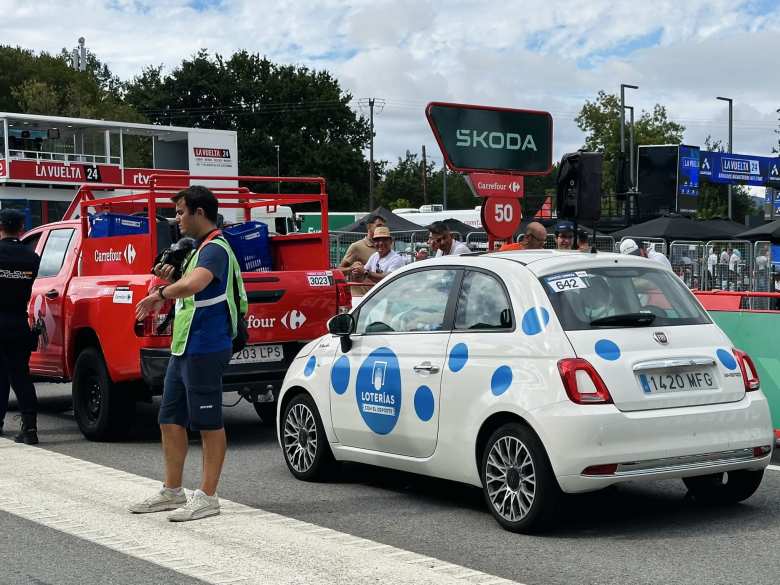 The publicity caravan stopped at the tech campus. Here is a white FIAT 500 with blue polka dots representing Loterías, behind a red Carrefour pickup truck.